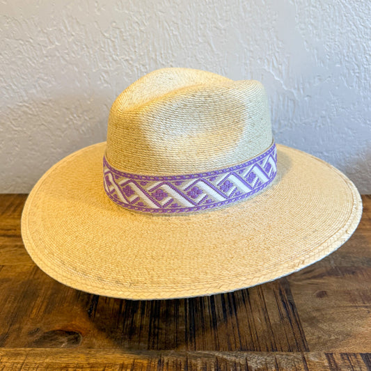 Women's straw palm leaf hat with custom purple and white patterned band. 
